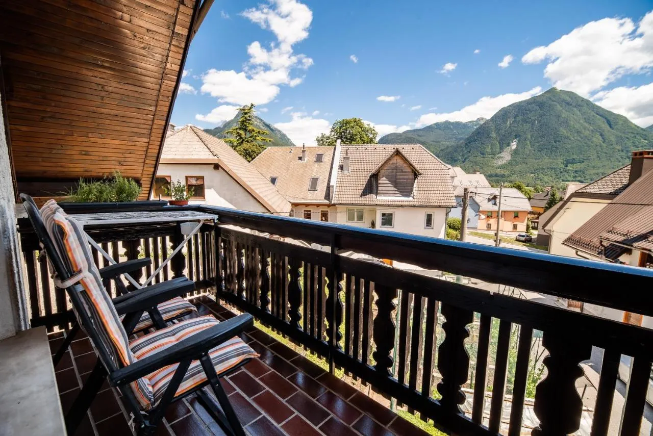 Balkon apartmaja 1 z leseno ograjo in pogledom čez strehe Bovca na gore