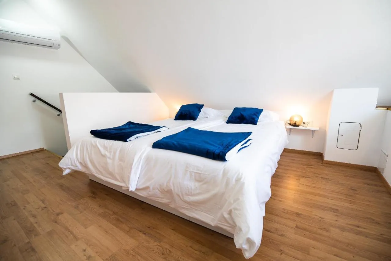 Spalnica apartmaja 1 s klimo na steni in ograjo stopnic