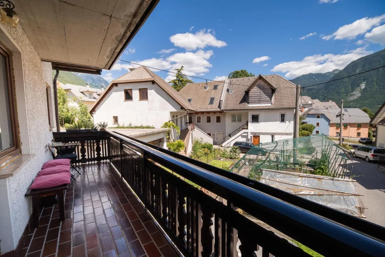 Balkon apartmaja 3 z leseno ograjo in pogledom na hiše in gore